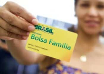 Pessoa que depende do Bolsa Família segurando o cartão do benefício