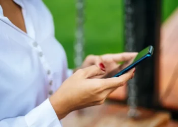 Pessoa usando o celular para consultar informações do Bolsa Família pelo WhatsApp