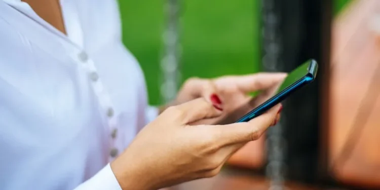 Pessoa usando o celular para consultar informações do Bolsa Família pelo WhatsApp