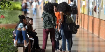 Imagem de alunos do Pé de Meia conversando no corredor do colégio.