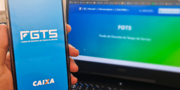 Imagem de um celular e uma tela de computador mostrando a página do FGTS para o saque aniversário