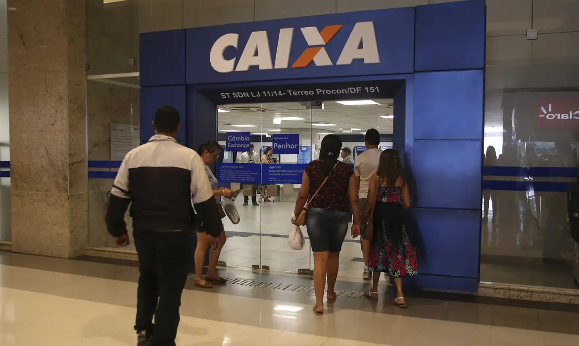 Imagem de pessoas entrando na agência da Caixa Econômica Federal para solicitar o Saque emergencial.