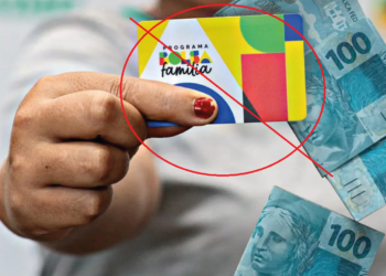 Cartão do programa Bolsa Família sendo segurado, com dinheiro em reais ao fundo, e imagem com aviso de bloqueio ou suspensão do benefício.