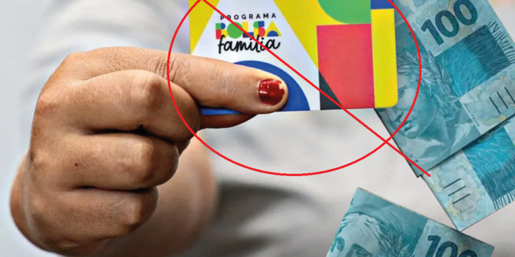 Cartão do programa Bolsa Família sendo segurado, com dinheiro em reais ao fundo, e imagem com aviso de bloqueio ou suspensão do benefício.