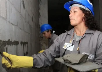 Mulheres trabalhadoras realizando a reconstrução de um imóvel, representando o auxílio para famílias em situação de vulnerabilidade.