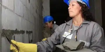 Mulheres trabalhadoras realizando a reconstrução de um imóvel, representando o auxílio para famílias em situação de vulnerabilidade.
