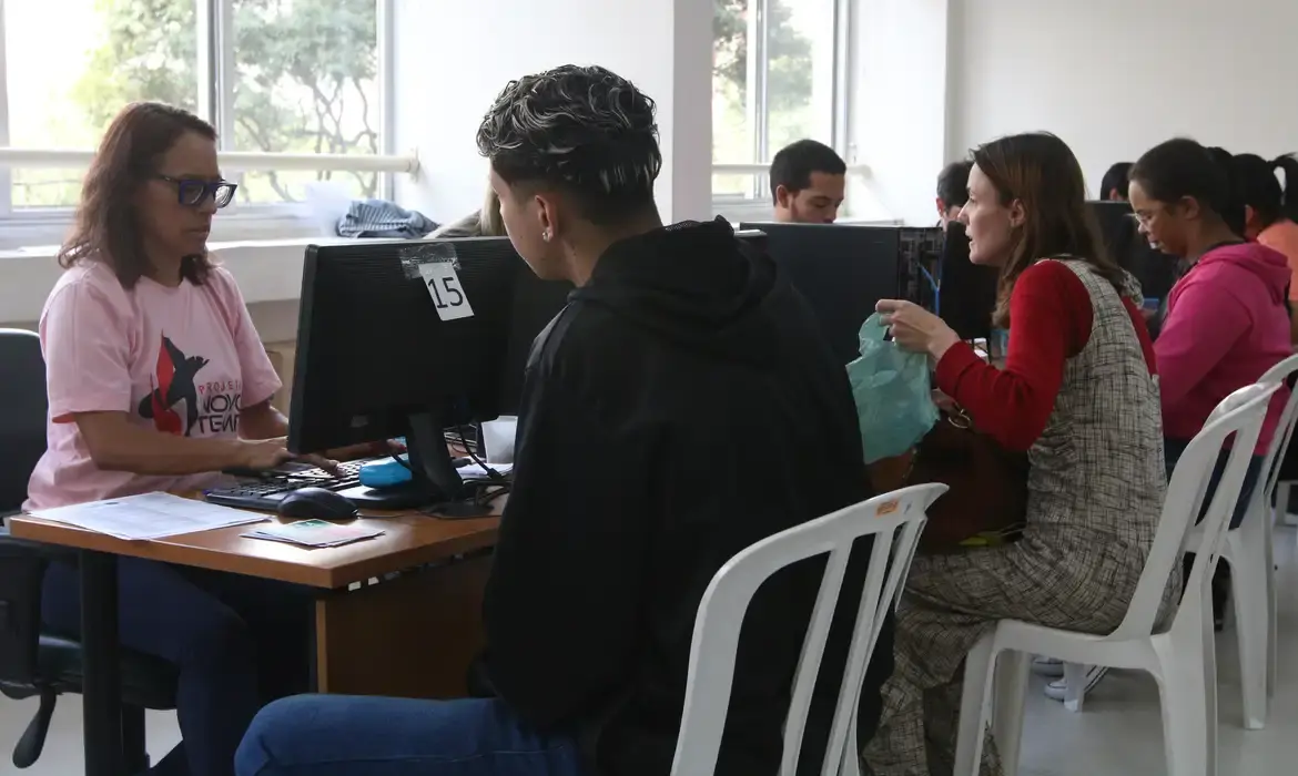 Pessoas participando do cadastro do Auxílio Reconstrução em um escritório.