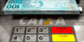 Cédulas de R$ 100 sendo retiradas de caixa eletrônico da CAIXA.