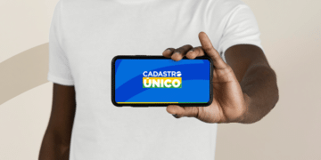 Pessoa segurando celular com logo do Cadastro Único na tela, simbolizando a atualização digital.