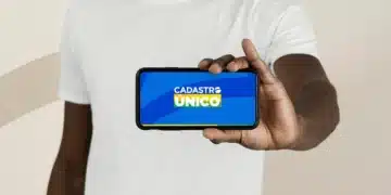 Pessoa segurando smartphone com logo do Cadastro Único na tela.