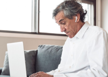 Idoso utilizando um laptop para acessar informações online.