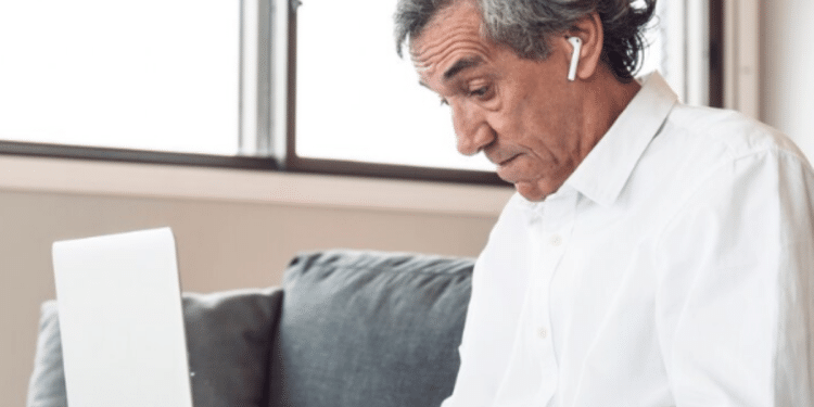 Idoso utilizando um laptop para acessar informações online.