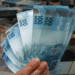 Notas de R$ 100, representando o valor do abono salarial do PIS/Pasep que pode ser retirado pelos trabalhadores.