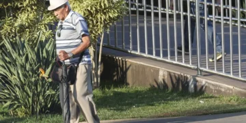 Idoso caminhando com uma bengala, indo realizar a prova de vida.