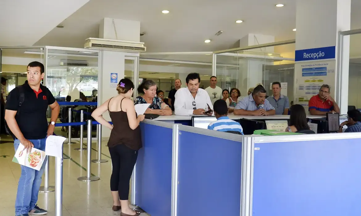  Pessoas aguardando atendimento presencial em agência do INSS.