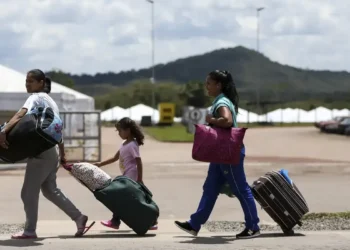 Famílias de imigrantes brasileiros retornando ao Brasil, com malas e bolsas.