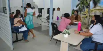 Atendimento no mutirão do Bolsa Família e Cadastro Único, com cidadãos sendo assistidos em um espaço de atendimento social.