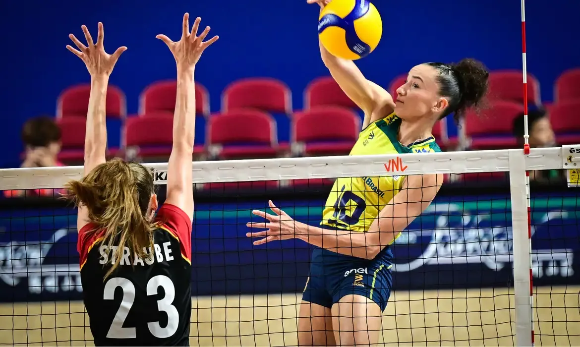 Jogadora de vôlei atacando a bola durante partida, representando a dedicação exigida aos atletas.