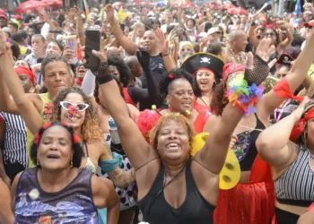Multidão animada celebrando o carnaval com fantasias coloridas.