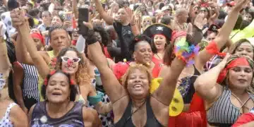 Multidão animada celebrando o carnaval com fantasias coloridas.