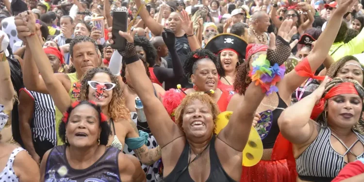 Multidão animada celebrando o carnaval com fantasias coloridas.