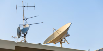 Antenas de TV e satélite instaladas em telhado, captando sinais para transmissão.