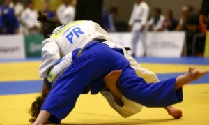 Atleta de judô em ação, durante competição, ilustrando os critérios para o Bolsa Talento Esportivo.