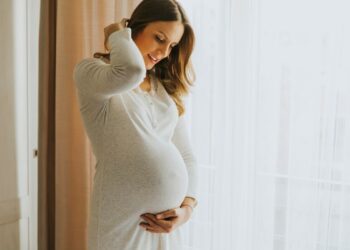 Mulher grávida em uma pose descontraída, representando a elegibilidade para o salário-maternidade.
