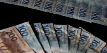 Notas de R$ 100 e R$ 200, representando os valores que trabalhadores podem receber no mês do seu aniversário através do saque-aniversário do FGTS.