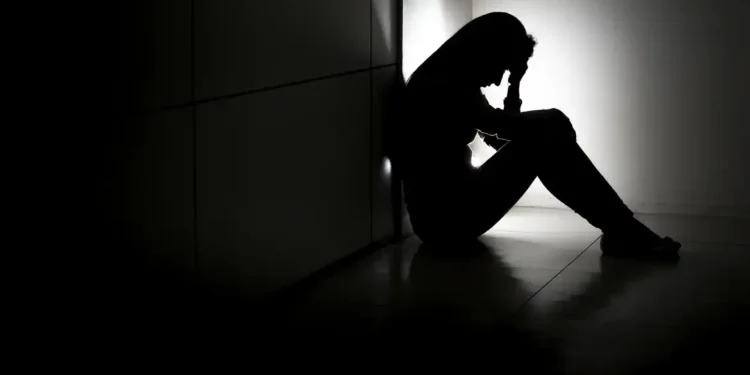 Mulher com expressão de preocupação sentada em um ambiente iluminado, simbolizando a importância da saúde mental e o apoio às pessoas com transtornos mentais.