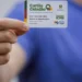 Imagem de um beneficiário segurando o Cartão de Cidadania do Devolve ICMS, usado para acessar os valores devolvidos pelo programa.