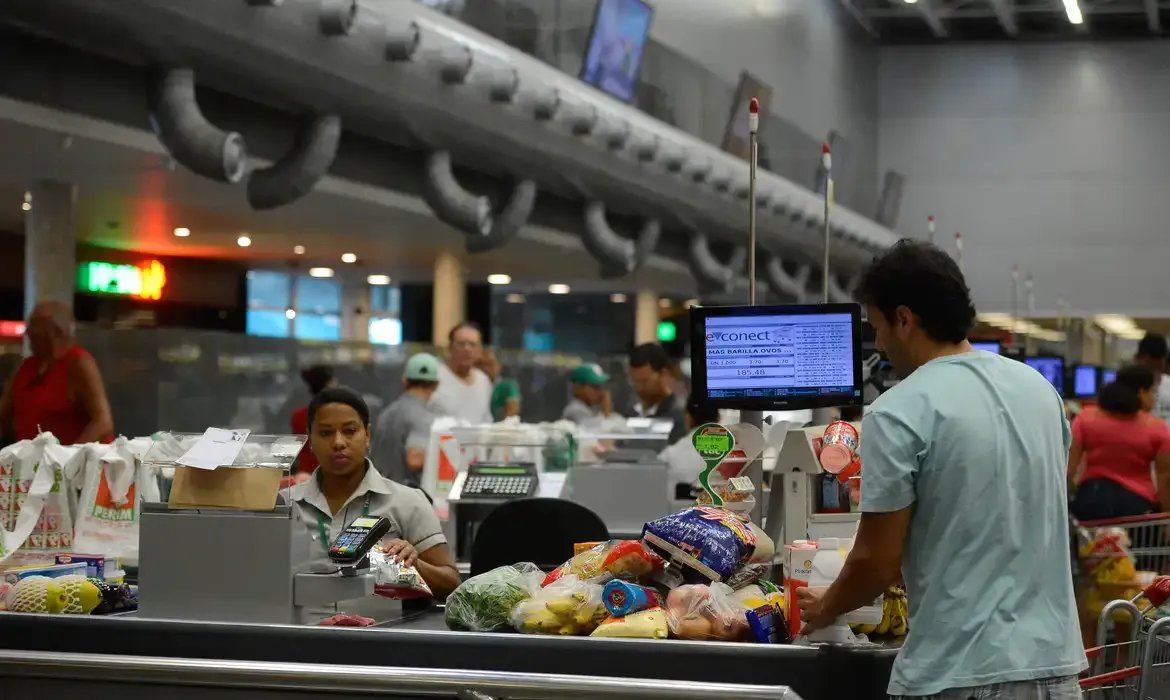 Cliente realizando compras no supermercado, ilustrando a mecânica do programa que oferece bilhetes para sorteios.