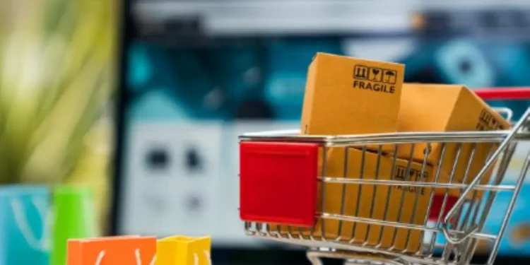 "Carrinho de compras com pacotes frágil ao fundo de um site de e-commerce."