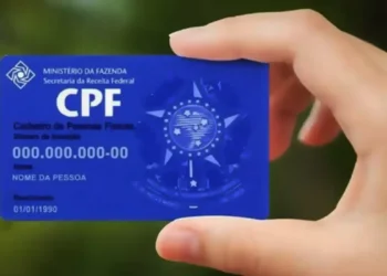 Cartão do CPF sendo segurado por uma mão, representando a inclusão do documento na nota fiscal.