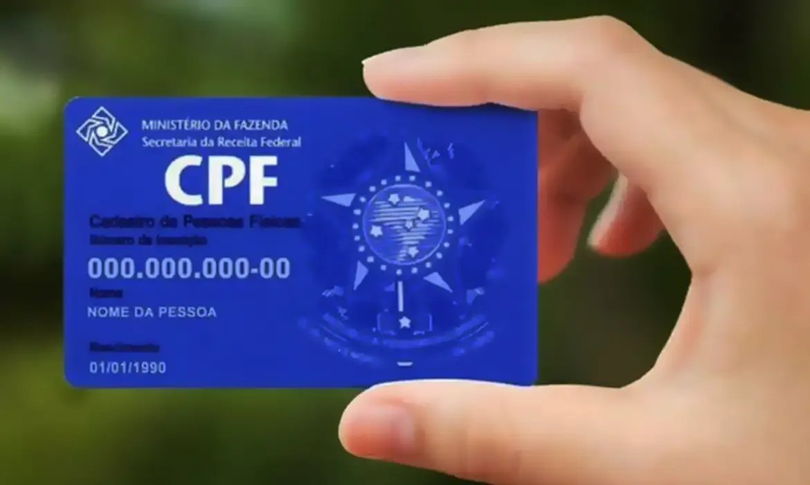 Cartão do CPF sendo segurado por uma mão, representando a inclusão do documento na nota fiscal.