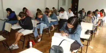 Alunos do ensino médio realizado prova em sala de aula, representando os critérios para participação no programa Pé-de-Meia 2025.
