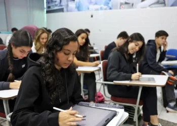 Estudantes em sala de aula utilizando tablets para estudo.