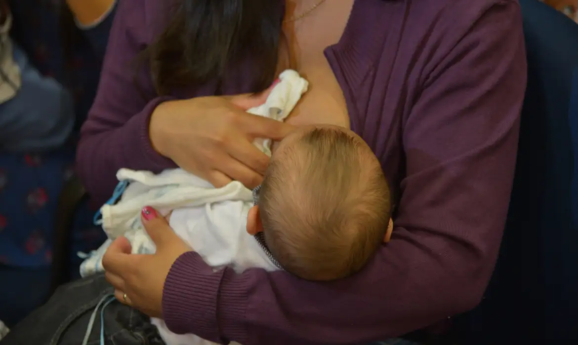 Mãe amamentando seu filho, atendendo aos critérios do programa para crianças de 0 a 6 anos em Pernambuco.