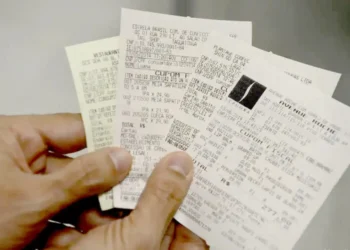 Pessoa segurando vários cupons fiscais para participar do sorteio de R$ 200 mil.