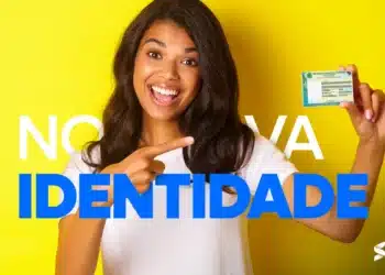 Pessoa segurando a nova Carteira de Identidade Nacional, sorrindo e apontando para o documento