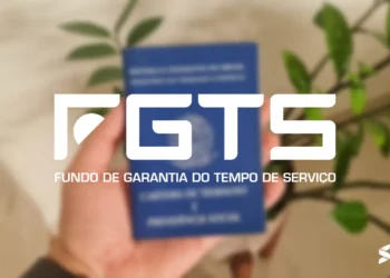Carteira de trabalho segurada por uma mão, com destaque para o logotipo do FGTS.