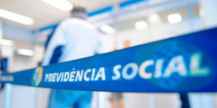 Fila de atendimento em agência do INSS com foco em faixa de isolamento com o nome Previdência Social.