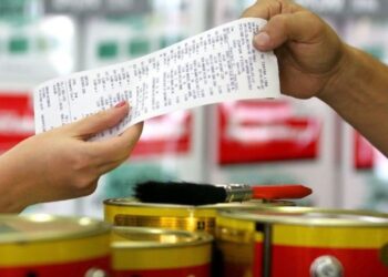 Pessoa recebendo uma nota fiscal de compra em loja de tintas