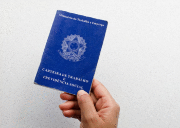 Pessoa segurando a Carteira de Trabalho e Previdência Social azul do Brasil