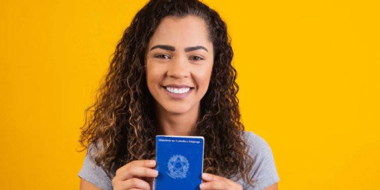 Jovem segurando a Carteira de Trabalho com sorriso no rosto, representando esperança no mercado de trabalho formal.