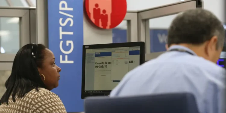 "Imagem de uma pessoa consultando o PIS na Caixa Econômica, com tela de consulta no computador."