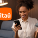 Mulher usando o aplicativo do Itaú para verificar informações com cartão em mãos.