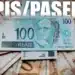Notas de 100 reais e fundo PIS/Pasep ilustrando o pagamento do benefício no Brasil.