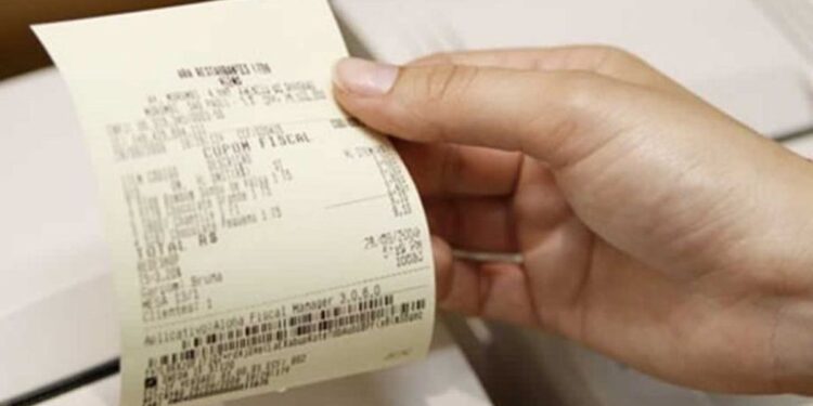 Pessoa retirando um cupom fiscal de uma impressora de recibos.