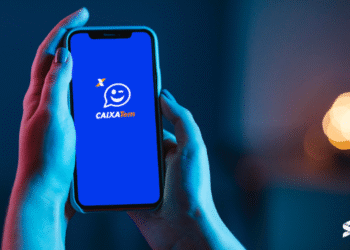 Pessoa segurando celular com aplicativo Caixa Tem aberto, relacionado aos novos pagamentos liberados.